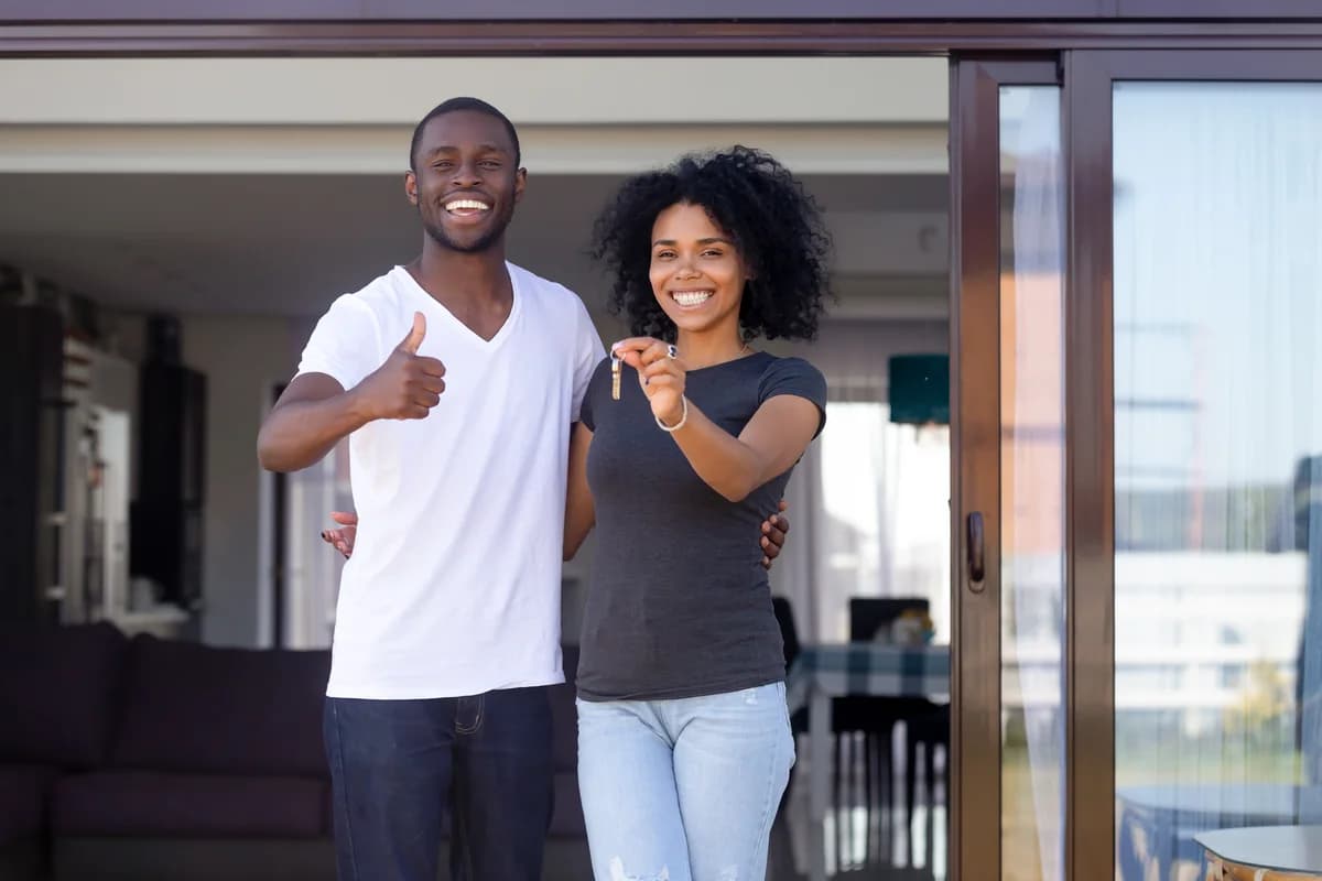 Un couple de membres devant son logement, les clés en main
