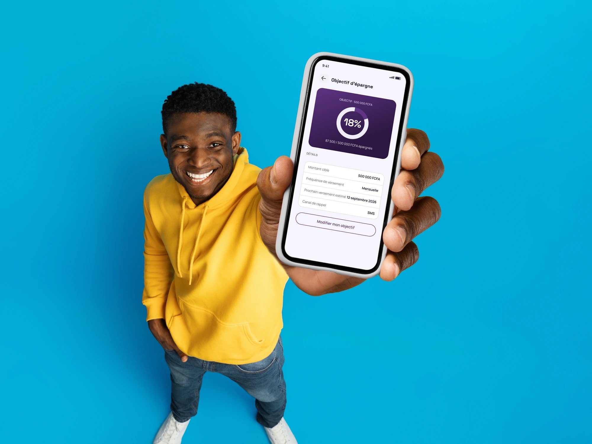 Un jeune homme montre son objectif d'épargne ResiCoop sur son téléphone